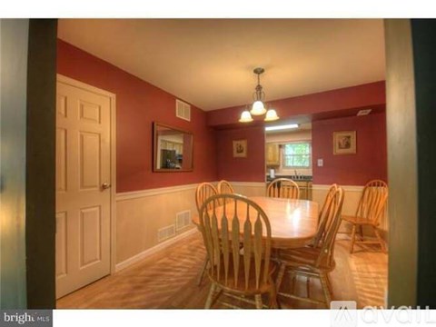 A dining room with a wooden table and chairs.