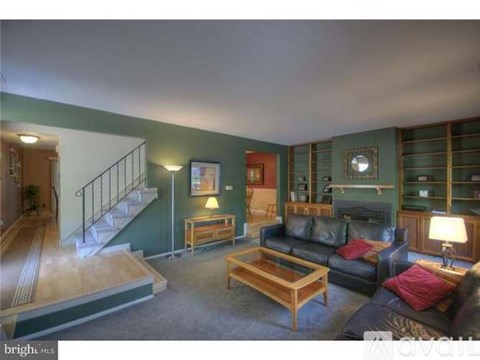 A living room with a couch, coffee table, and stairs.