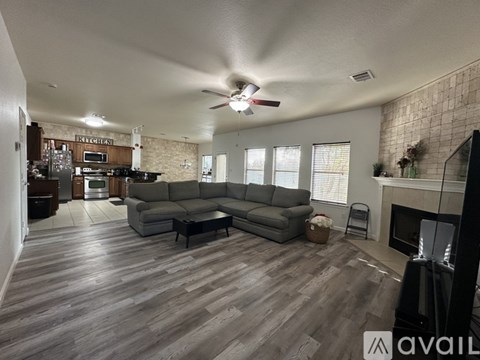 A living room with a grey sofa and a wooden floor.