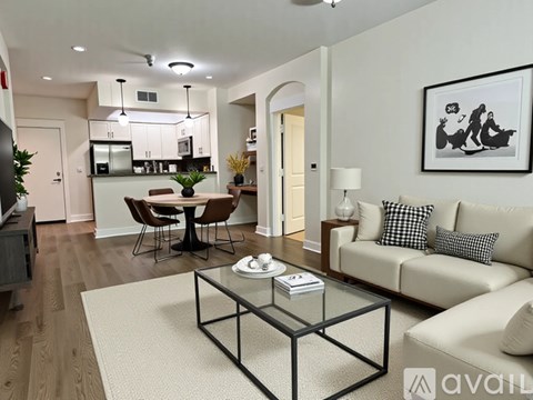 A modern living room with a glass coffee table and a sofa.