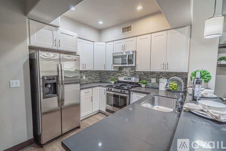 A modern kitchen with stainless steel appliances and white cabinets.