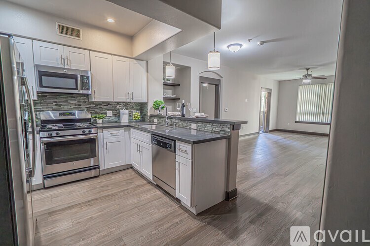A modern kitchen with a center island and stainless steel appliances.