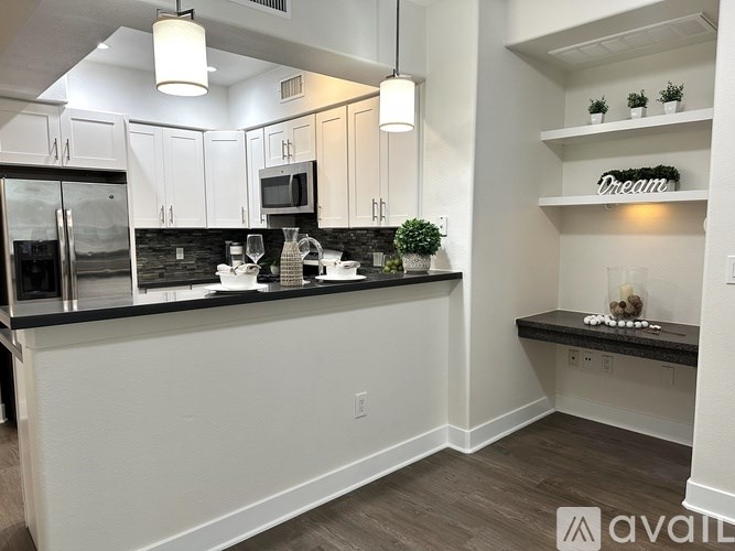 A kitchen with white cabinets and a black countertop.