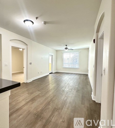 A spacious room with a ceiling fan and lighting fixtures.