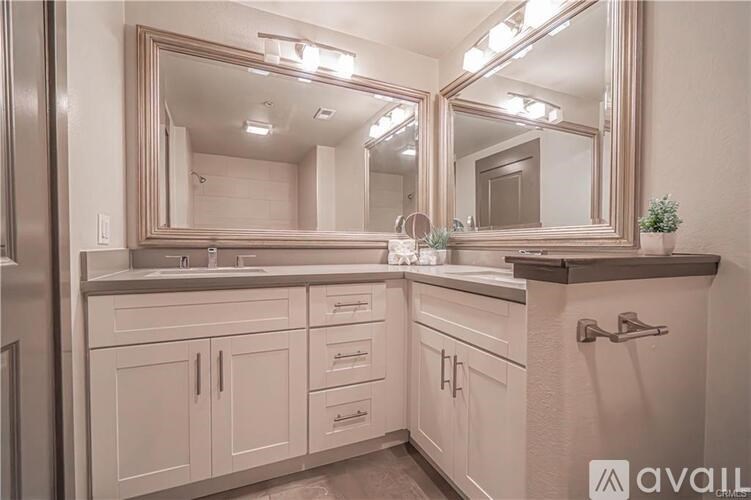 A bathroom with a vanity, sink, and mirror.