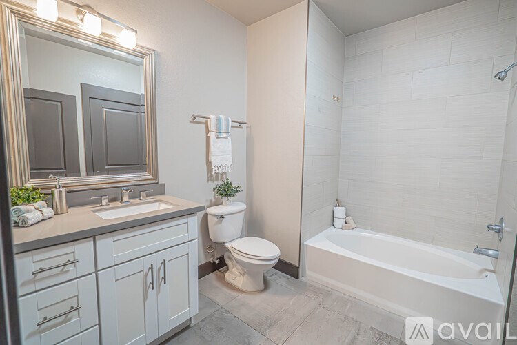 A bathroom with a white tub, toilet, and sink.