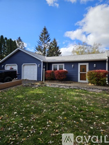 A car window shows a view of a garage and a pile of items outside.
