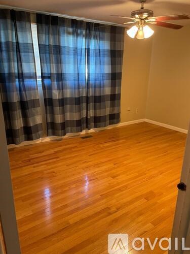 A room with wooden flooring and a ceiling fan.