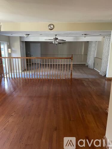 A room with wooden floors and a ceiling fan.