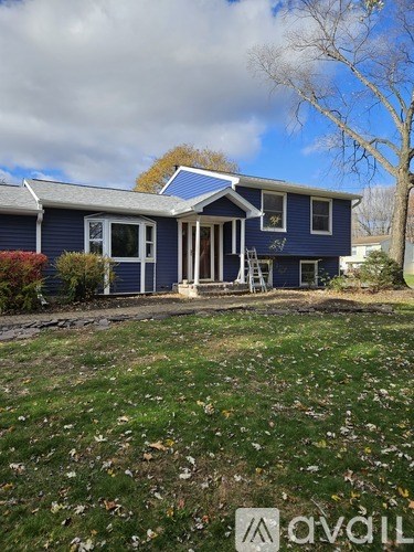A living room with a ceiling fan and a staircase.