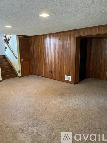 A room with a carpeted floor and wooden walls.