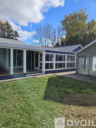 A room with wooden flooring and a window with black curtains.