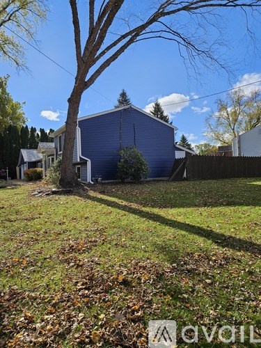 A room with wooden flooring and a purple wall.