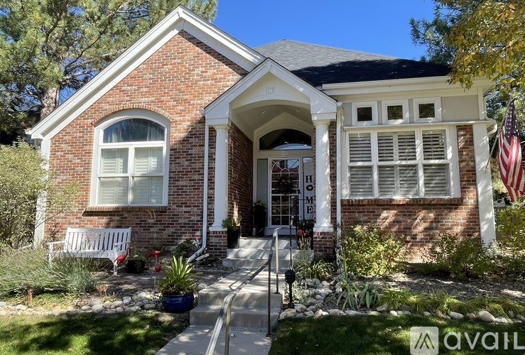 A house with a brick facade and a flag on the front porch.