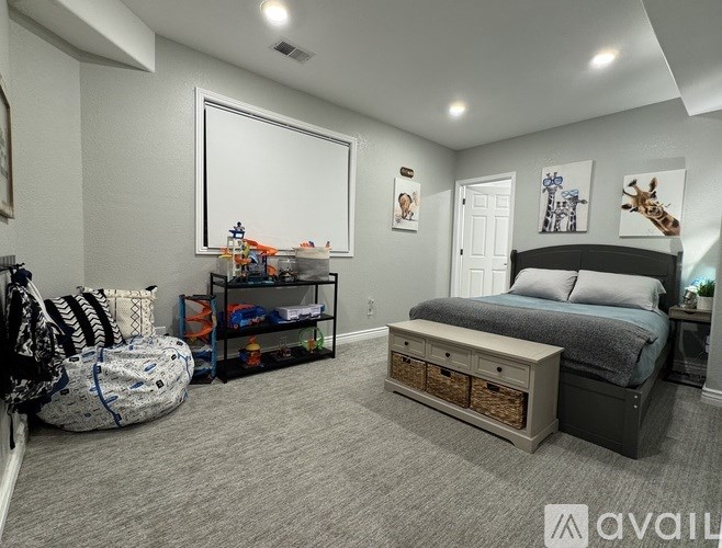 A bedroom with a large bed, a dresser, and a chair.