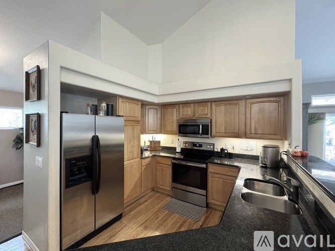 A kitchen with wooden cabinets and a stainless steel refrigerator.