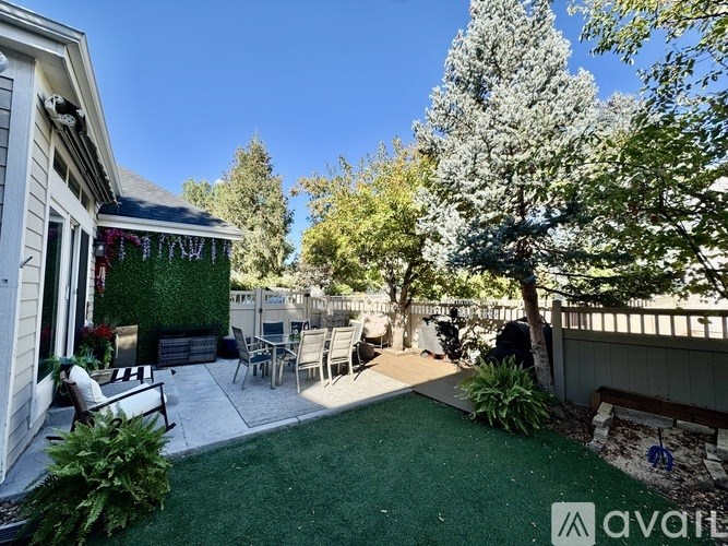 A backyard with a green lawn and a tree.