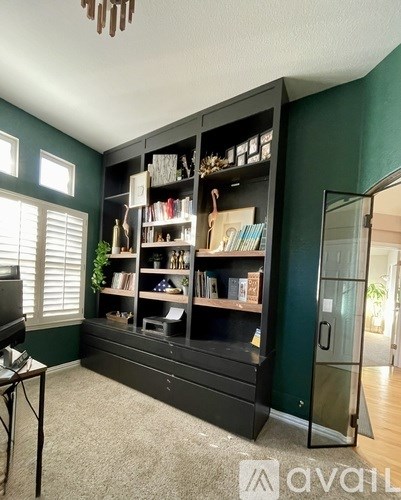 A black bookshelf with various books and decorations.