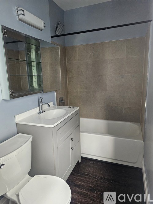 A bathroom with a white toilet, sink, and bathtub.