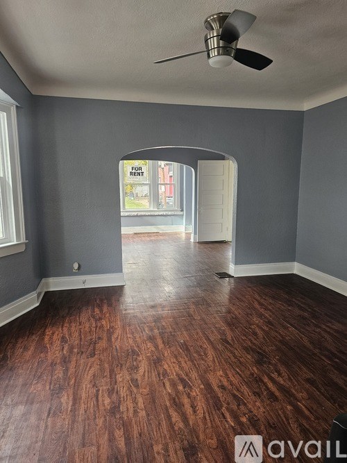 A room with wooden floors and a ceiling fan.
