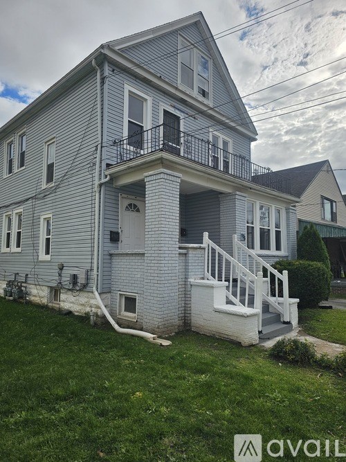 A two-story house with a balcony on the second floor.