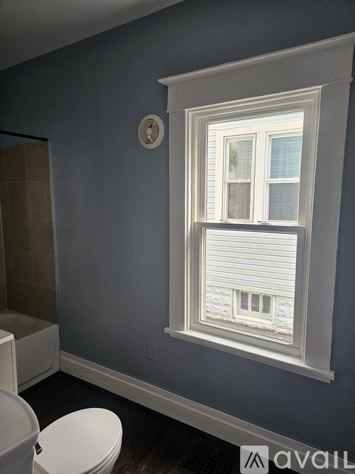 A bathroom with a toilet and a window.