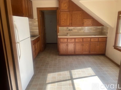 A kitchen with wooden cabinets and a white refrigerator.