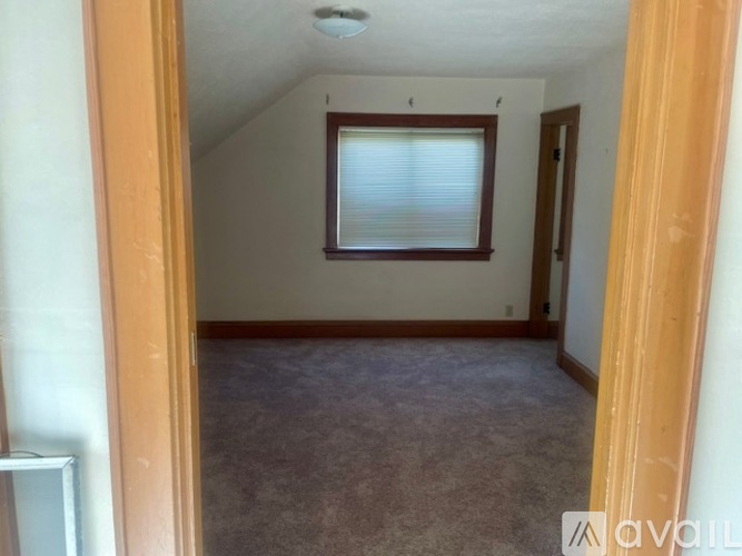A room with a window and carpeted floor.