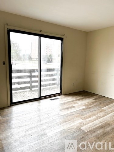 A room with a sliding glass door leading to a balcony.