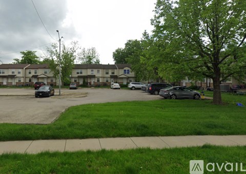 Apartment complex with cars parked in front.
