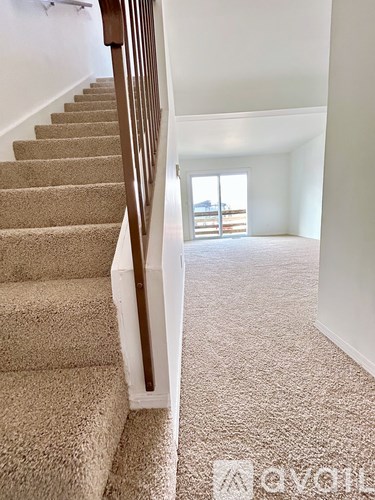 A carpeted staircase with a white railing.