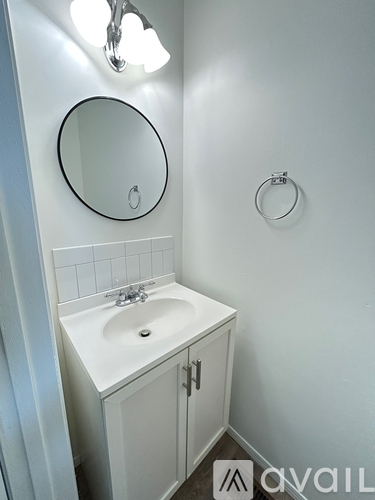 A small white bathroom with a sink and a mirror.