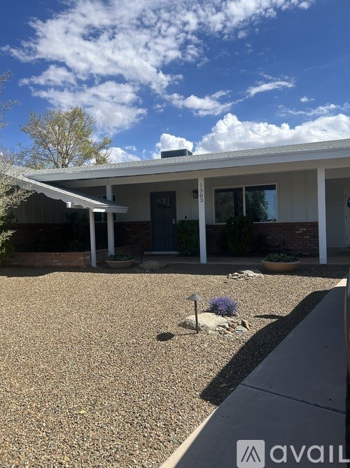 A house with a gravel driveway and a small garden in front.
