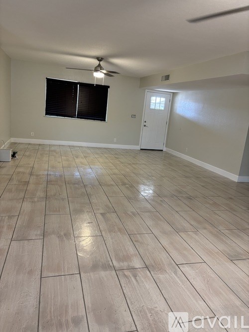 A room with wooden flooring and a ceiling fan.