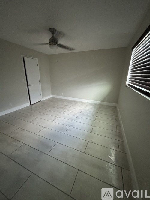 A room with a ceiling fan and tiled floor.