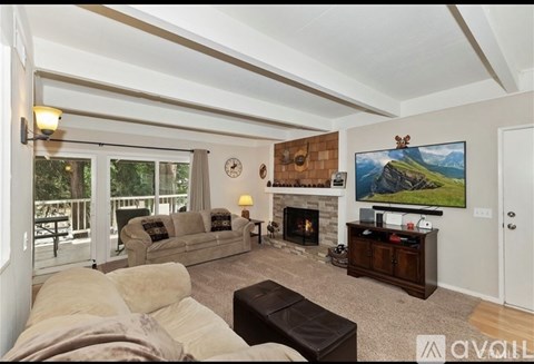 A living room with a fireplace and a painting of a mountain landscape on the wall.