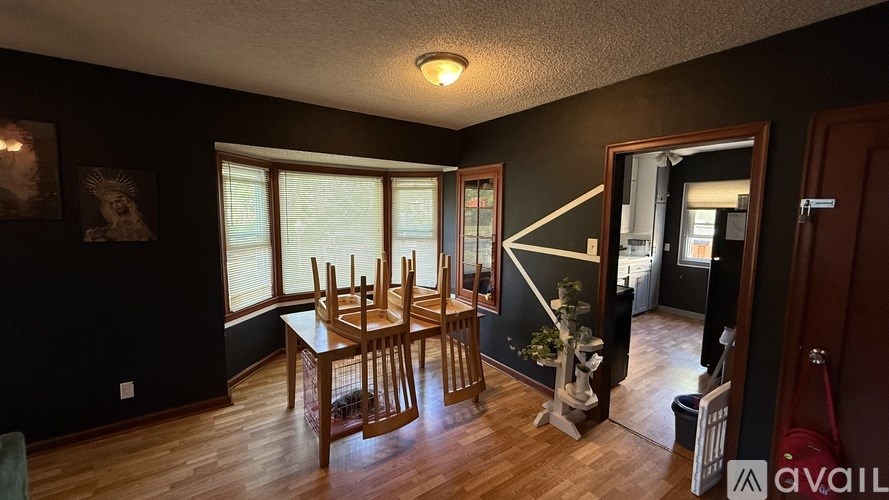 A dining room with a wooden table and chairs.