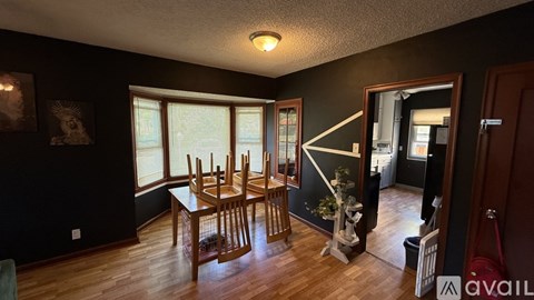 A dining room with a wooden table and chairs.