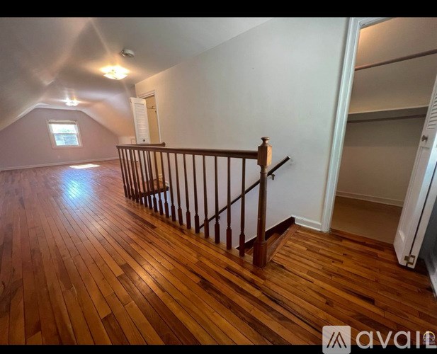 A wooden floor in a room with a staircase.