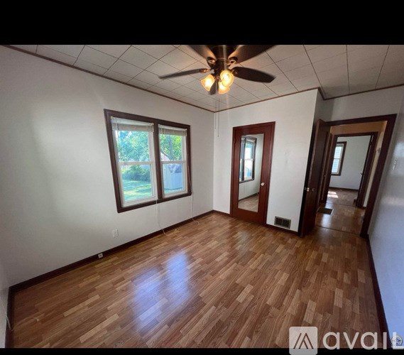 A room with wooden floors and a ceiling fan.