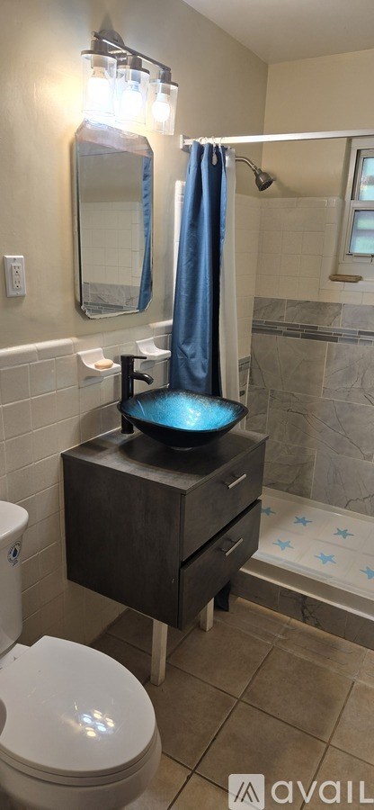 A bathroom with a toilet, sink, and shower.