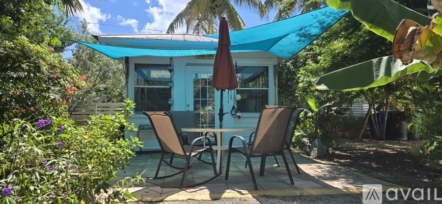 A patio with a table and chairs under a blue canopy.