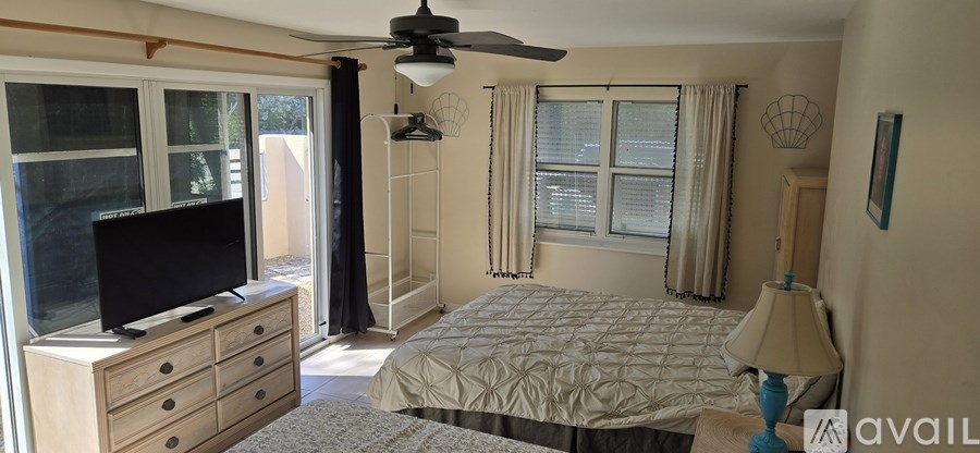 A bedroom with a bed, dresser, and television.