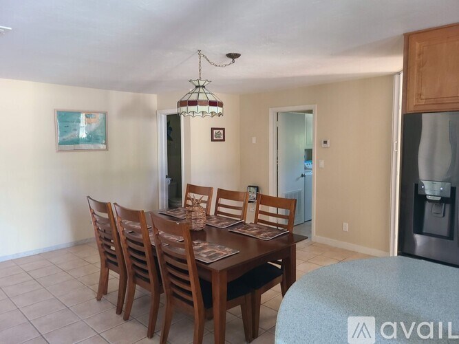 A dining room with a wooden table and chairs.