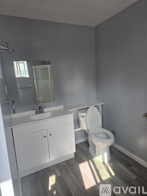 A bathroom with a toilet, sink, and cabinet.