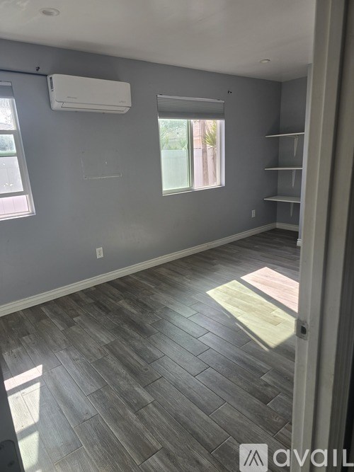 A room with a window and a wall-mounted air conditioner.