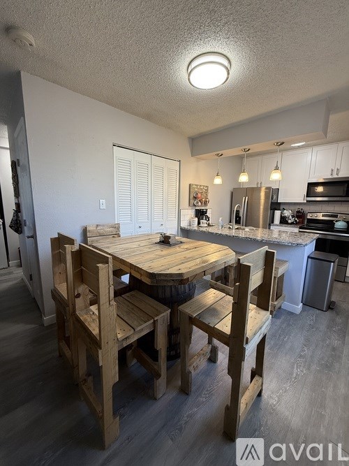 A kitchen with a table and chairs in the foreground.