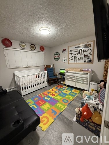 A baby's room with a white crib and a colorful rug.