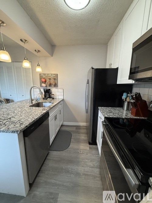 A kitchen with black appliances and white cabinets.