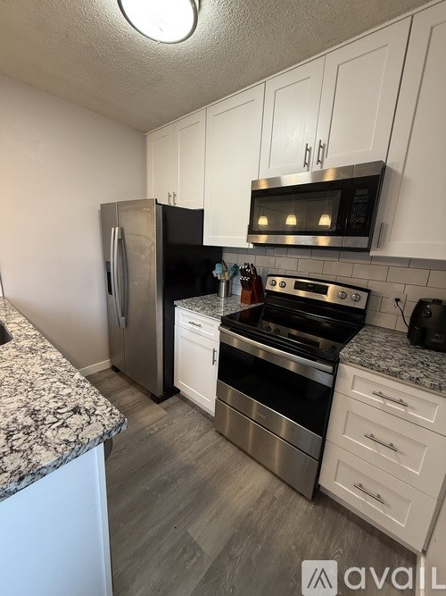 A kitchen with a granite countertop and stainless steel appliances.
